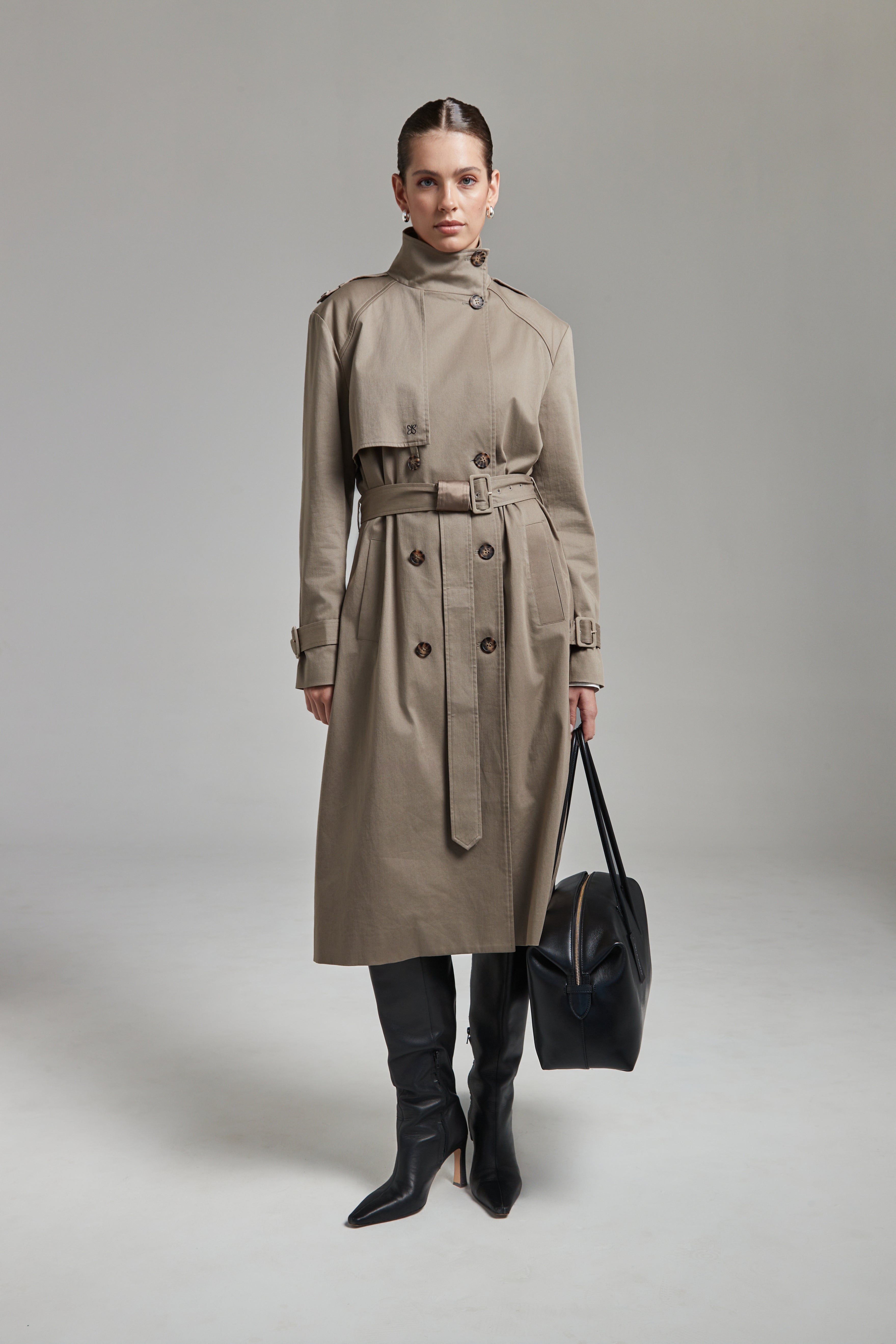 The Celeste Trench Coat in Desert Taupe shown full-length from the front with a funnel neckline and structured outerwear silhouette.