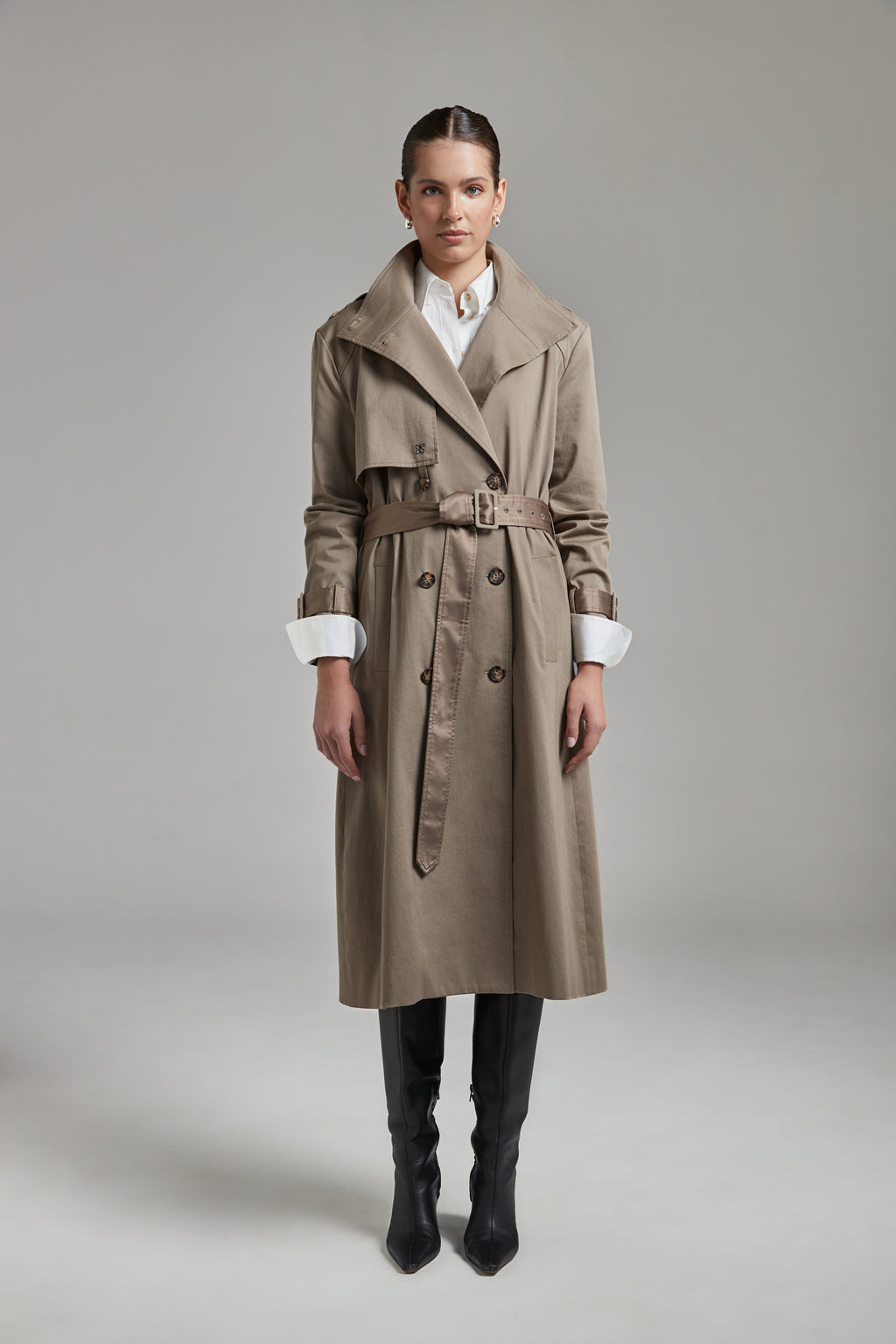 The Celeste Trench Coat in Desert Taupe shown full-length from the front with an open collar and structured outerwear silhouette.