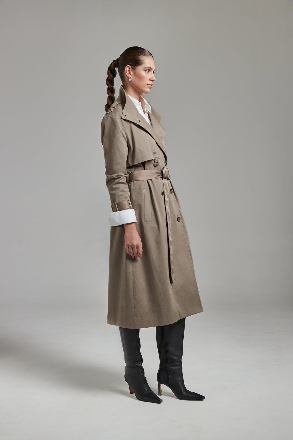 The Celeste Trench Coat in Desert Taupe shown from the side with an open collar, reversible belt detail and the Margot Shirt layered underneath.