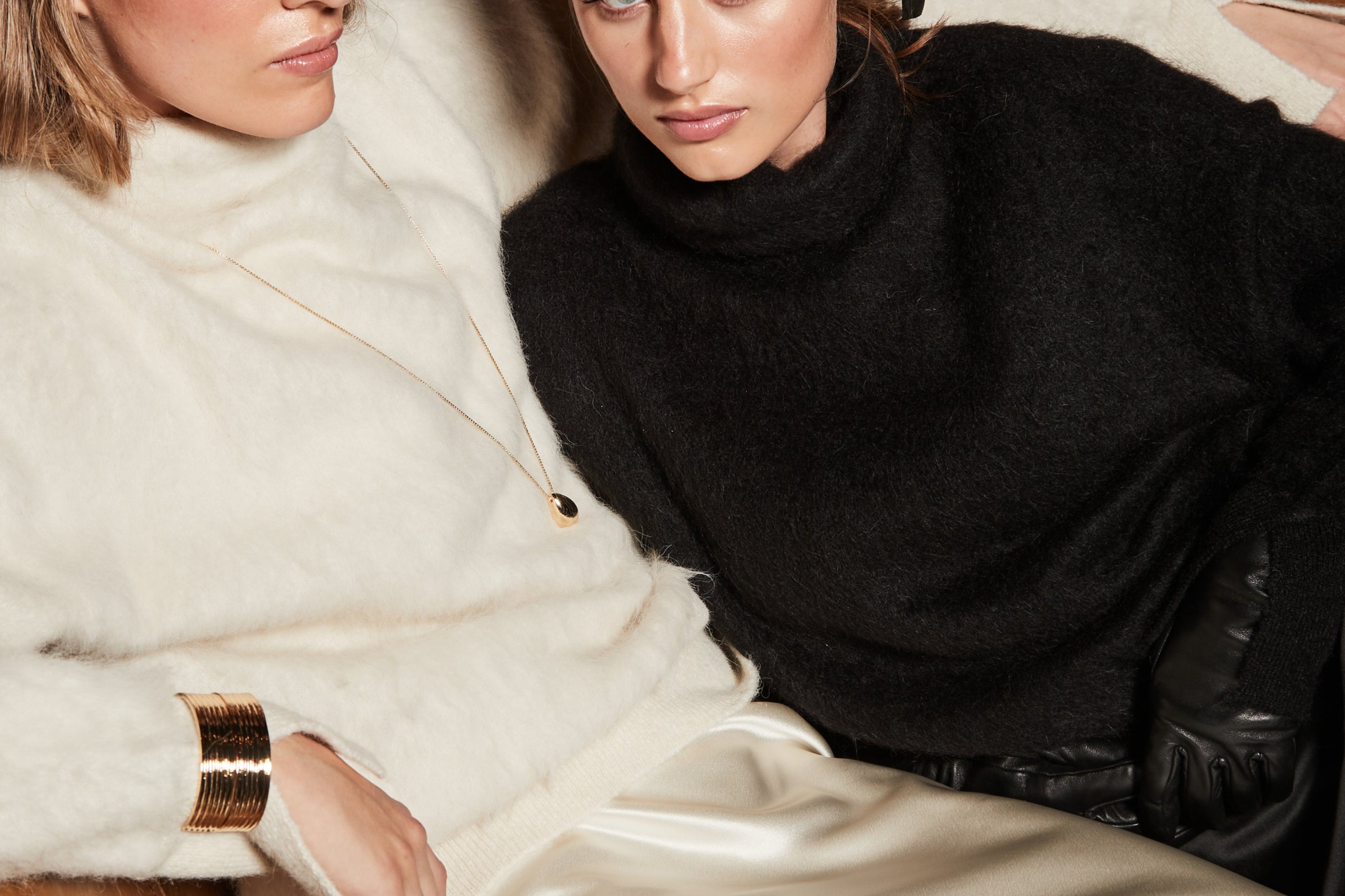 The Lauren Turtleneck and Anouk Maxi Skirt in Feather White and Midnight Black, styled as matching alpaca turtleneck knit and satin lace maxi skirt sets.