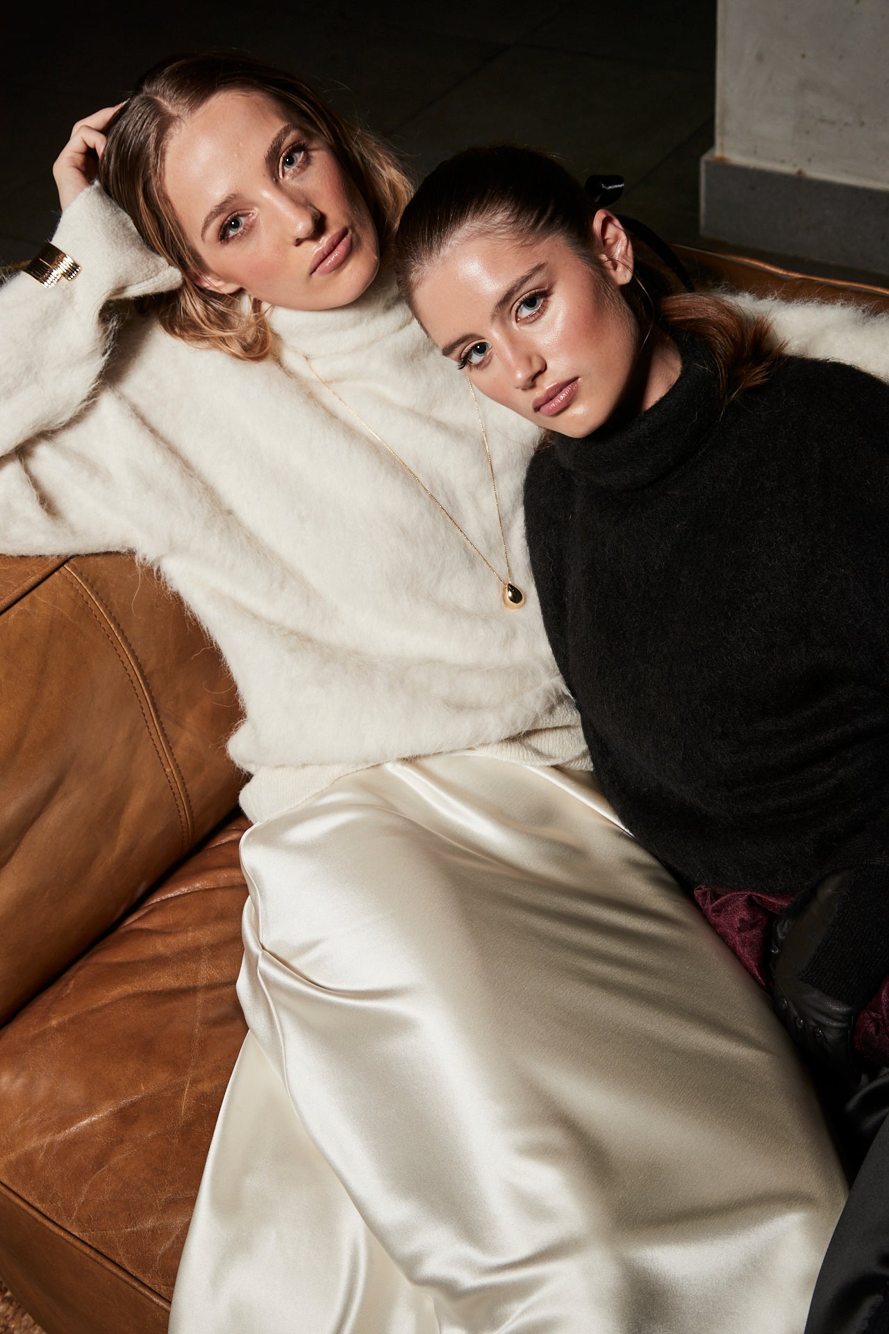 The Lauren Turtleneck and Anouk Maxi Skirt in Feather White and Midnight Black, styled as matching alpaca turtleneck knit and satin lace maxi skirt sets.
