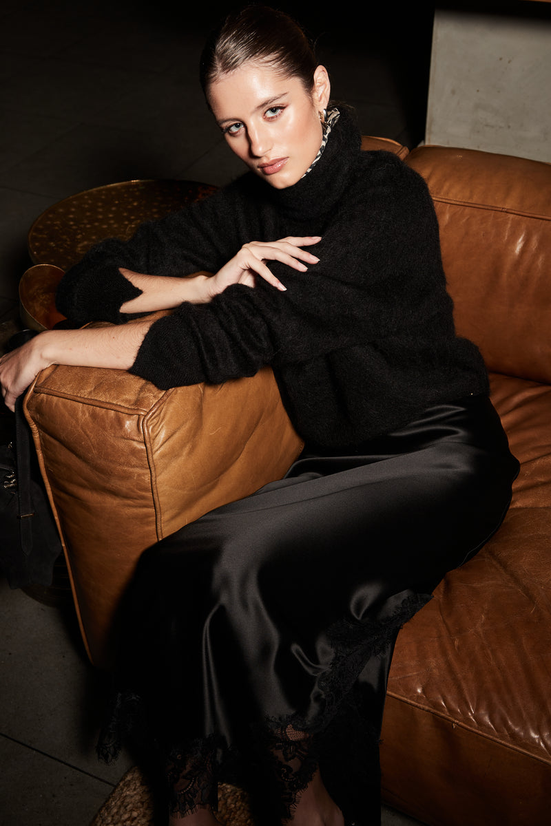 The Lauren Turtleneck and Anouk Maxi Skirt in Midnight Black, an alpaca turtleneck knit styled with a satin lace maxi skirt.
