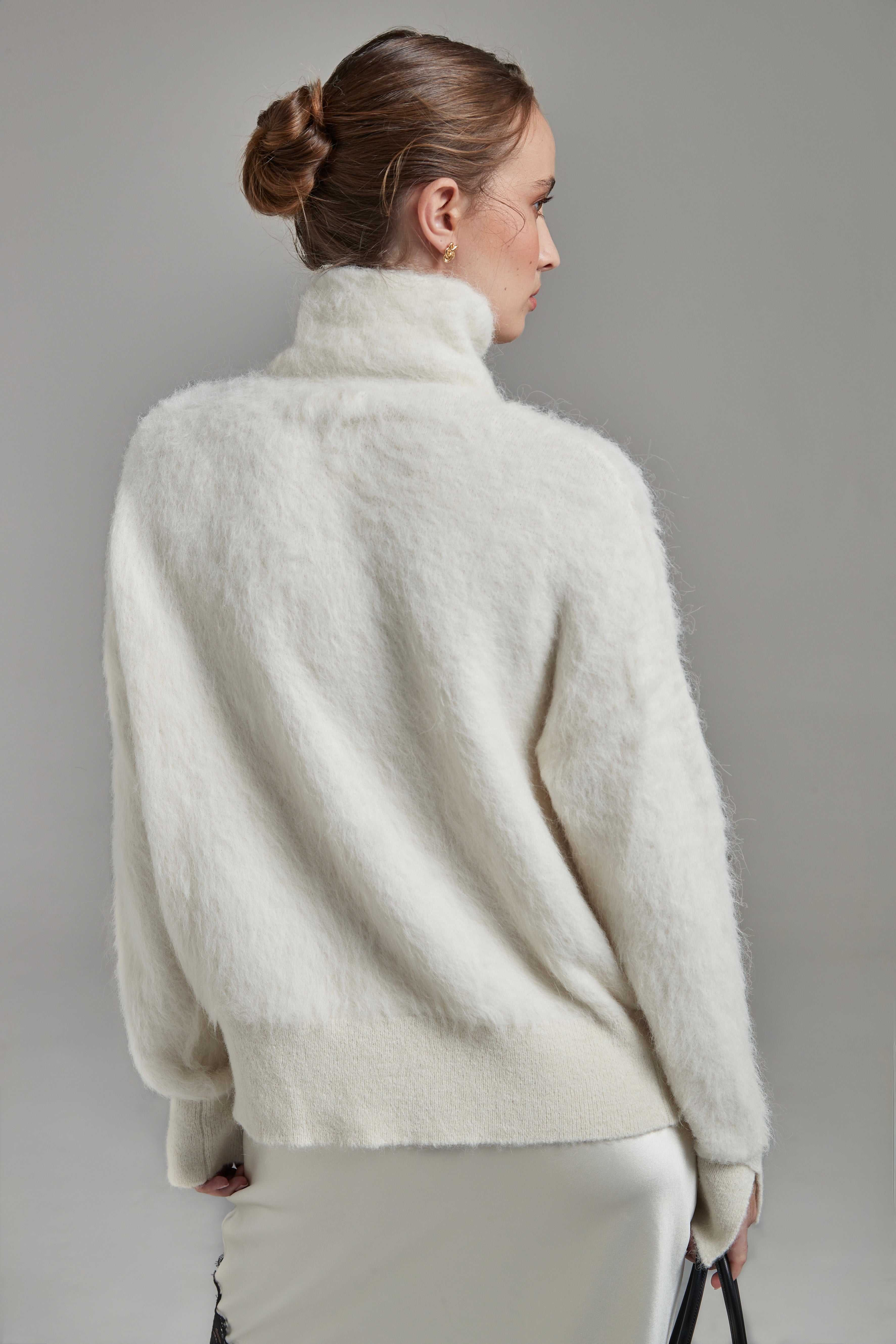 The Lauren Turtleneck in Feather White shown from the back with long sleeves, a brushed alpaca-blend texture and relaxed silhouette.