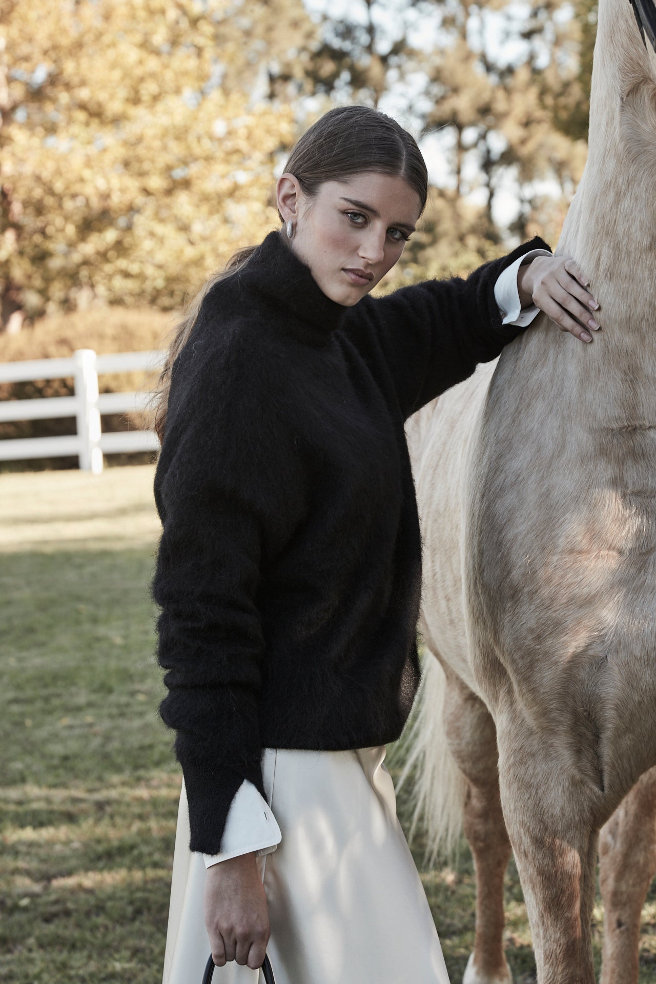 The Lauren Turtleneck in Midnight Black styled with the Margot Shirt in Cloud White and Anouk Maxi Skirt in Feather White, featuring an alpaca turtleneck knit, cotton shirt and satin lace maxi skirt.