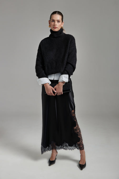 Model wearing the Lauren Turtleneck in Midnight Black layered over the Margot Shirt with the Anouk Maxi Skirt, shown full-length from the front with a brushed alpaca-blend knit and black lace trim.