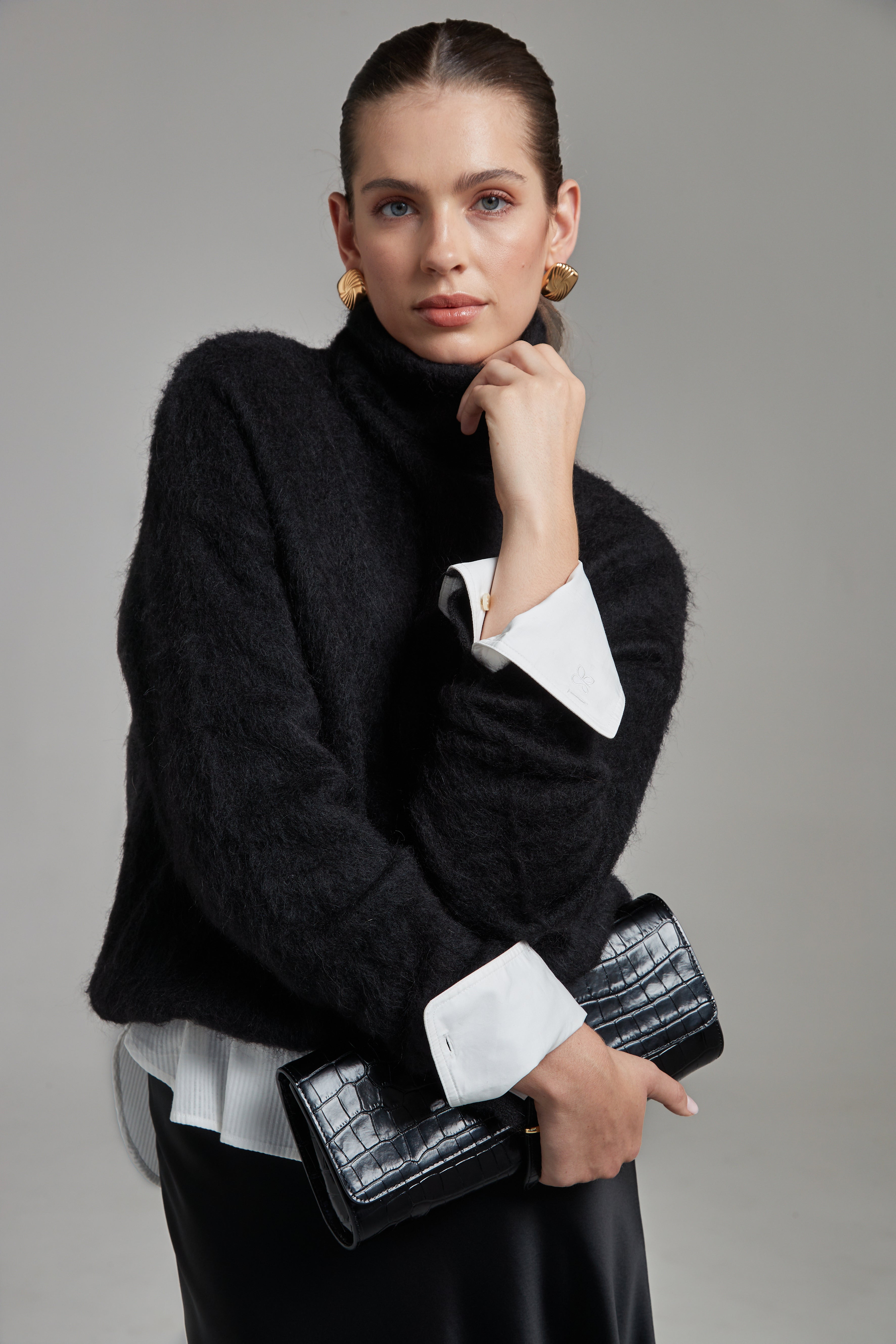 The Lauren Turtleneck in Midnight Black shown from the front layered over the Margot Shirt, featuring a brushed alpaca-blend texture and contrast shirting detail.