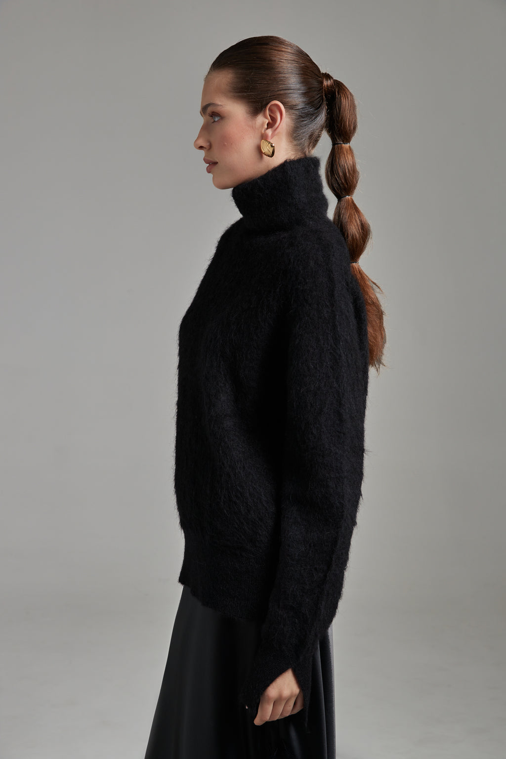 The Lauren Turtleneck in Midnight Black shown from the side with long sleeves, a brushed alpaca-blend texture and soft stretch.