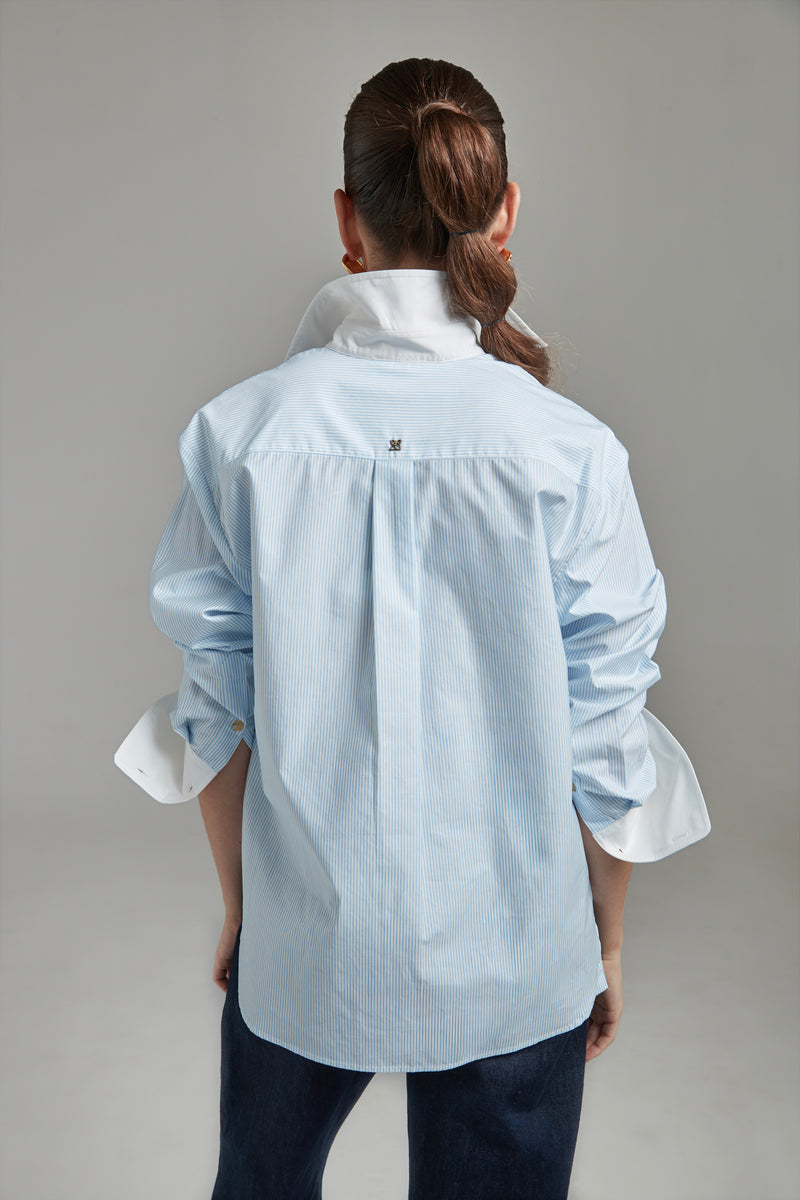 he Margot Shirt – All Tied Up in Blue/White Pinstripe shown from the back with logo hardware detailing and fine pinstripe cotton shirting.