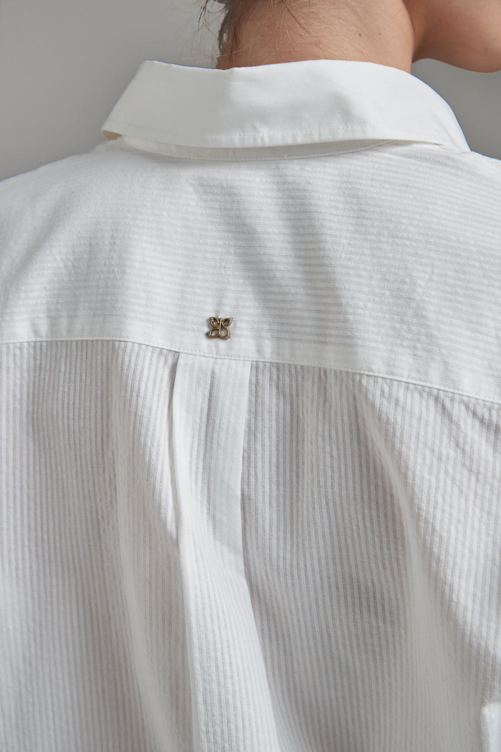 The Margot Shirt – All Tied Up in Blue/White Pinstripe, a cotton button-down shirt with back logo hardware detail.
