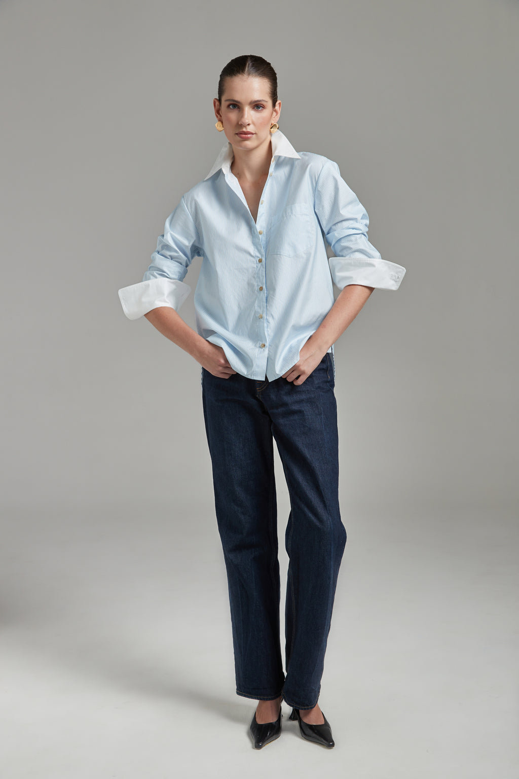 The Margot Shirt – All Tied Up in Blue/White Pinstripe shown full-length from the front with natural horn buttons, contrast collar and a cinched silhouette.
