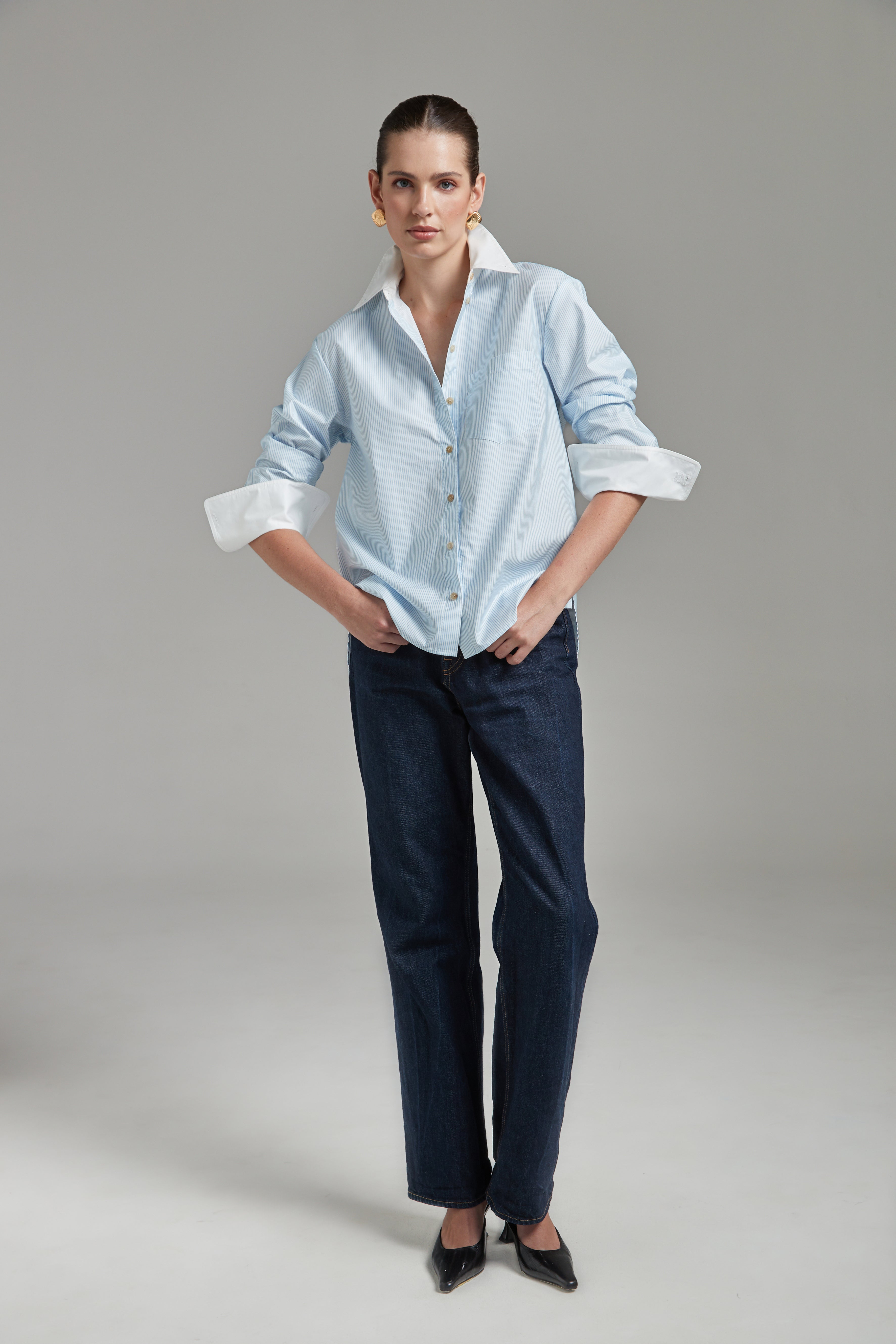 The Margot Shirt – All Tied Up in Blue/White Pinstripe shown full-length from the front with natural horn buttons, contrast collar and a cinched silhouette.