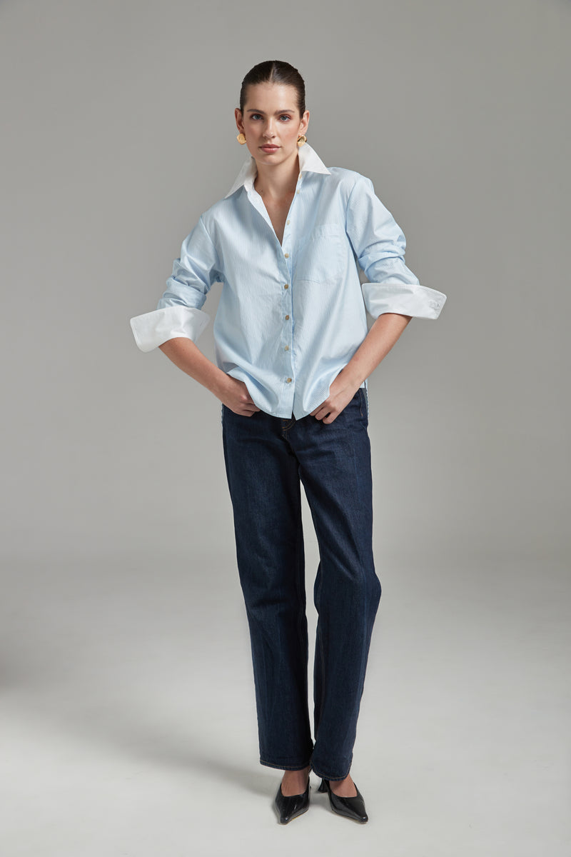 The Margot Shirt – All Tied Up in Blue/White Pinstripe shown full-length from the front with natural horn buttons, contrast collar and a cinched silhouette.