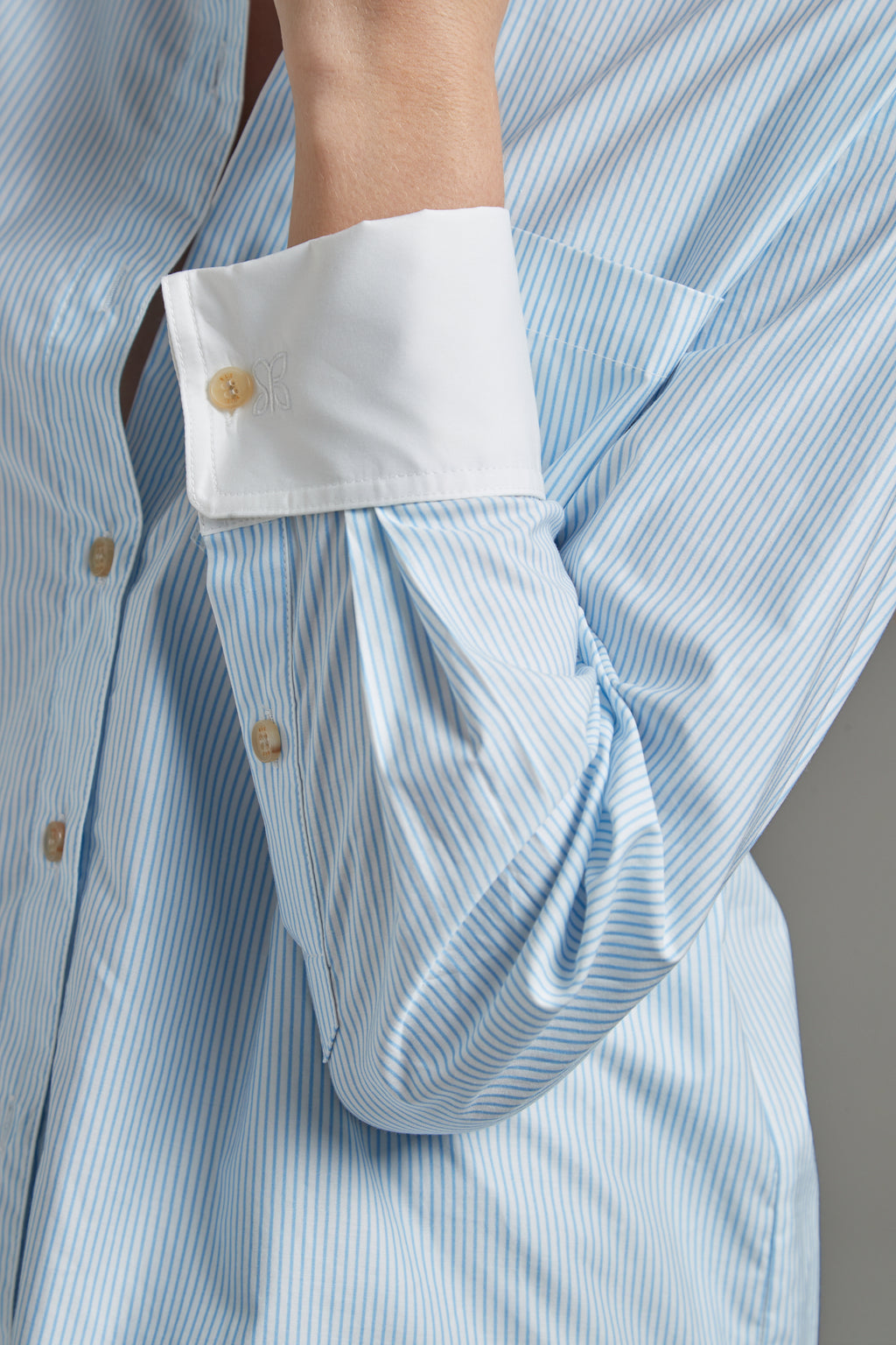 The Margot Shirt – All Tied Up in Blue/White Pinstripe shown close-up with natural horn button detailing and fine pinstripe cotton shirting.