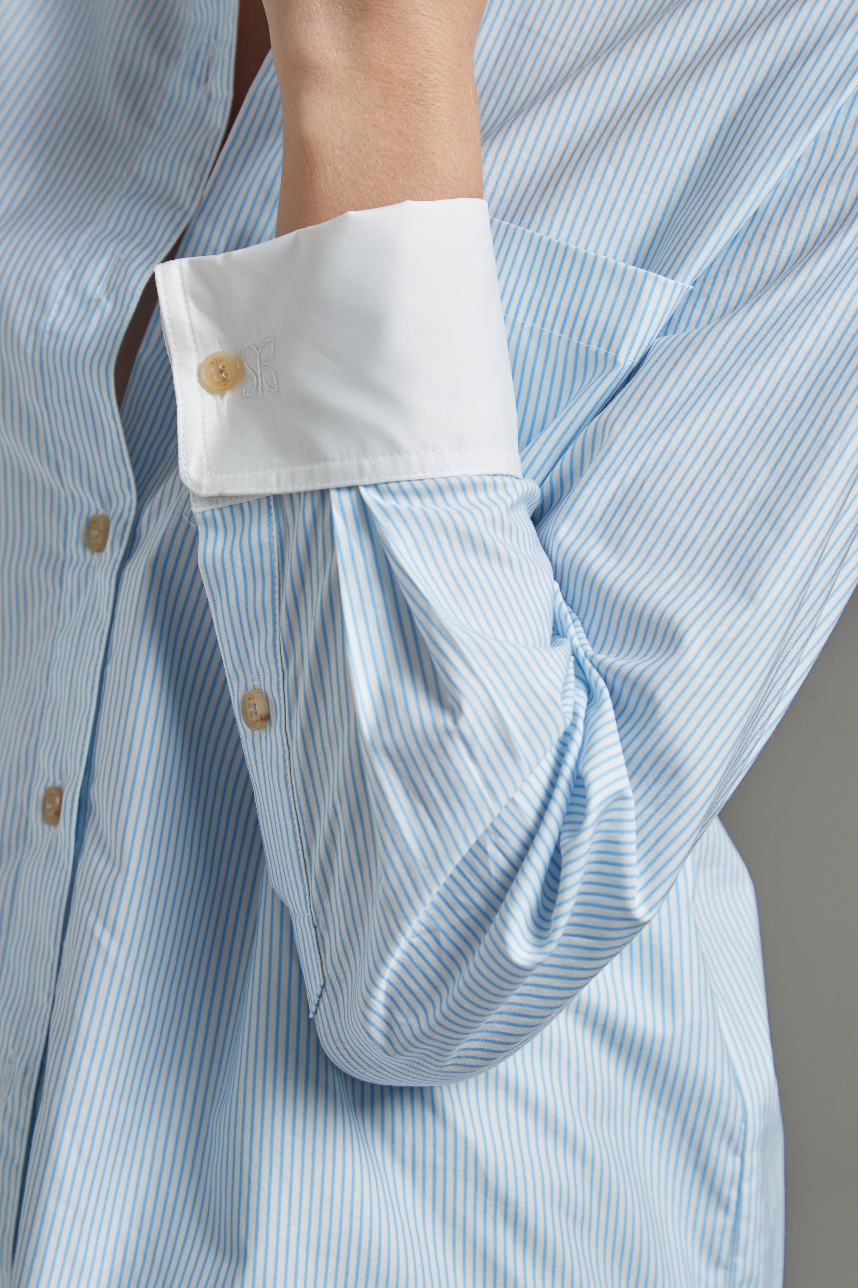 The Margot Shirt – All Tied Up in Blue/White Pinstripe shown close-up with natural horn button detailing and fine pinstripe cotton shirting.