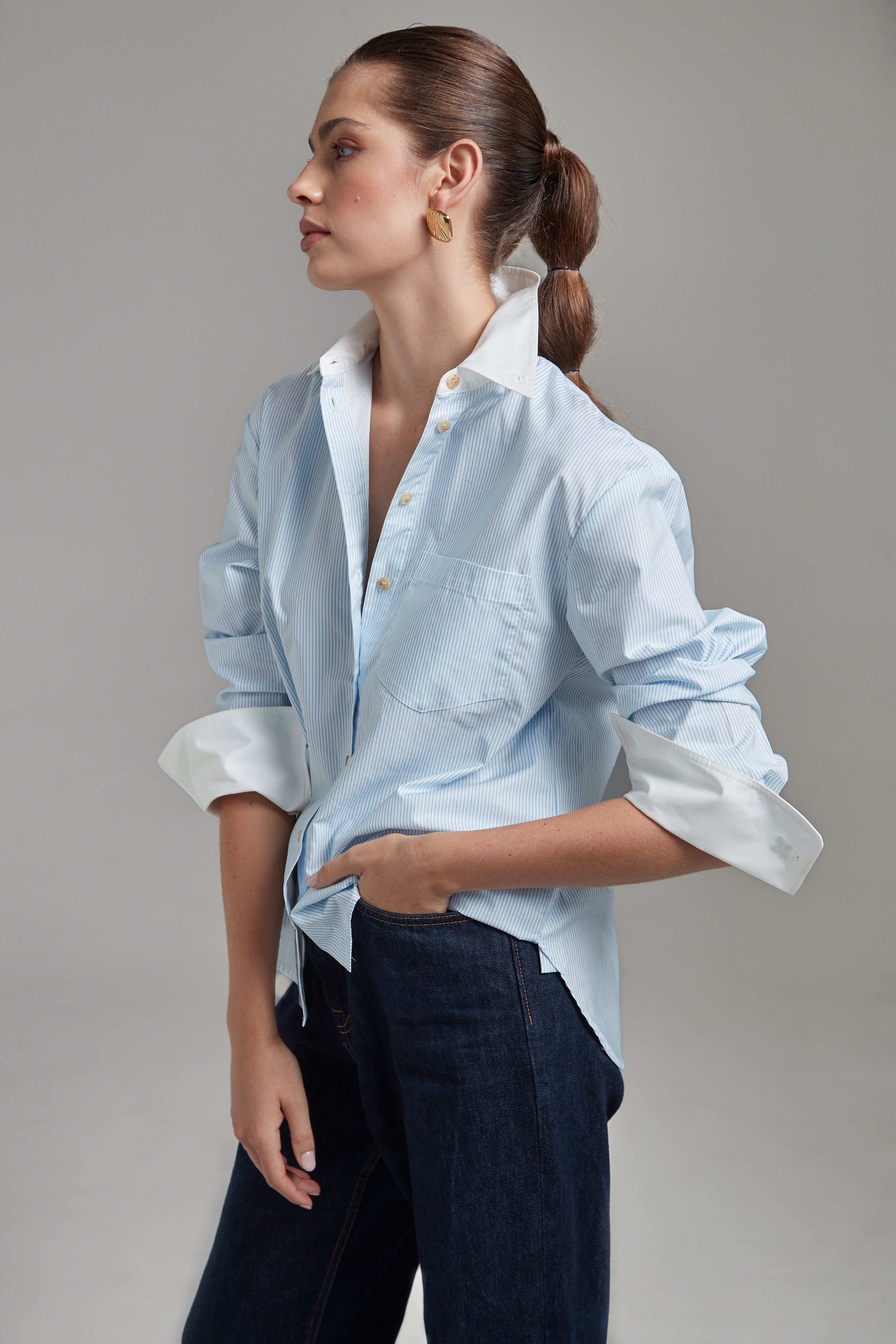 The Margot Shirt – All Tied Up in Blue/White Pinstripe shown from the side with a relaxed silhouette, contrast collar and cotton shirting detail.