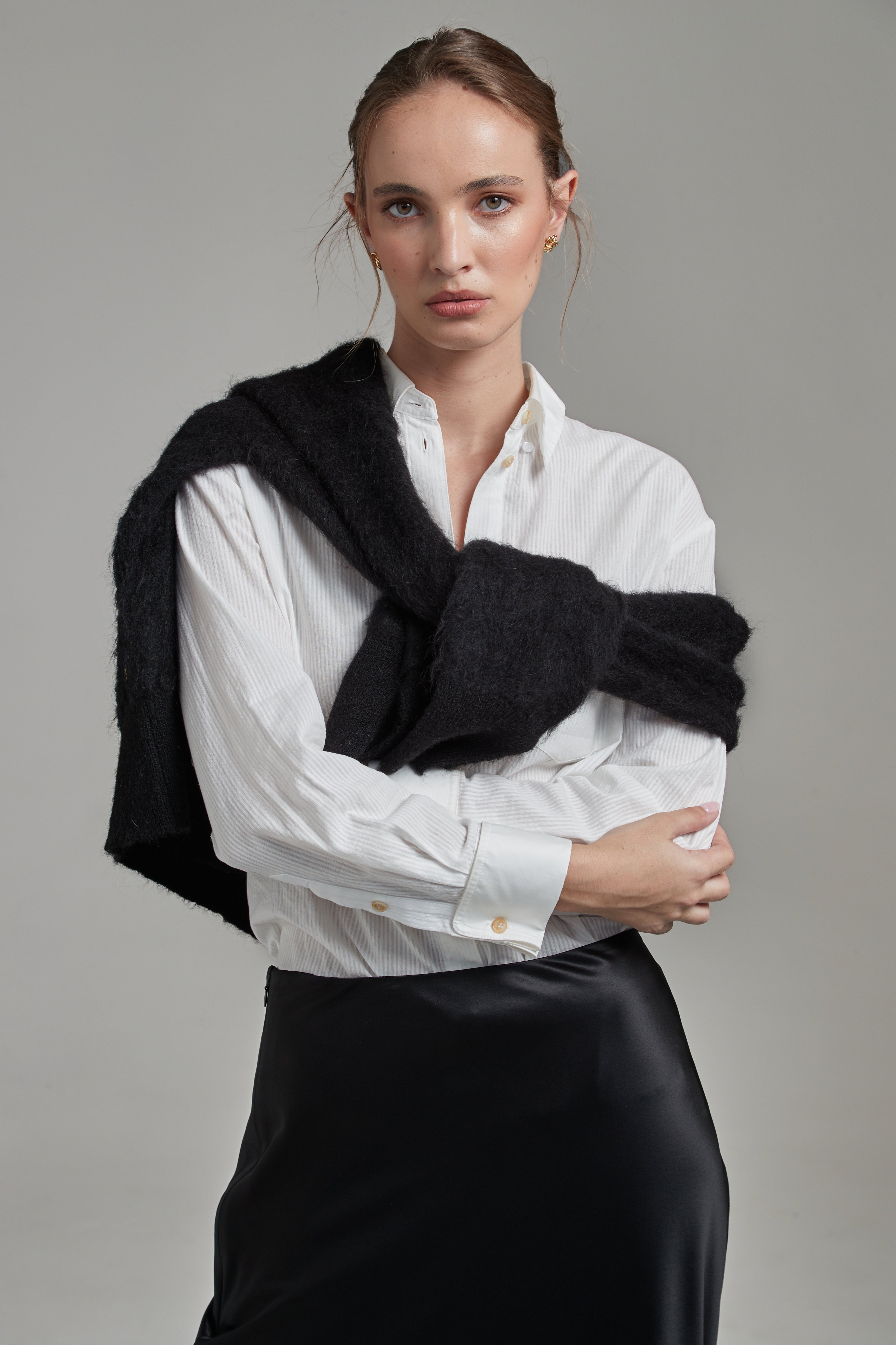 Model wearing the Margot Shirt in Cloud White styled with the Anya Mini Skirt and Lauren Turtleneck in Midnight Black, featuring cotton shirting, a wool-silk mini skirt and brushed alpaca-blend knitwear.