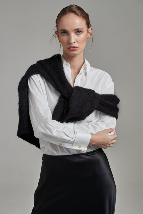 Model wearing the Margot Shirt in Cloud White styled with the Anya Mini Skirt and Lauren Turtleneck in Midnight Black, featuring cotton shirting, a wool-silk mini skirt and brushed alpaca-blend knitwear.