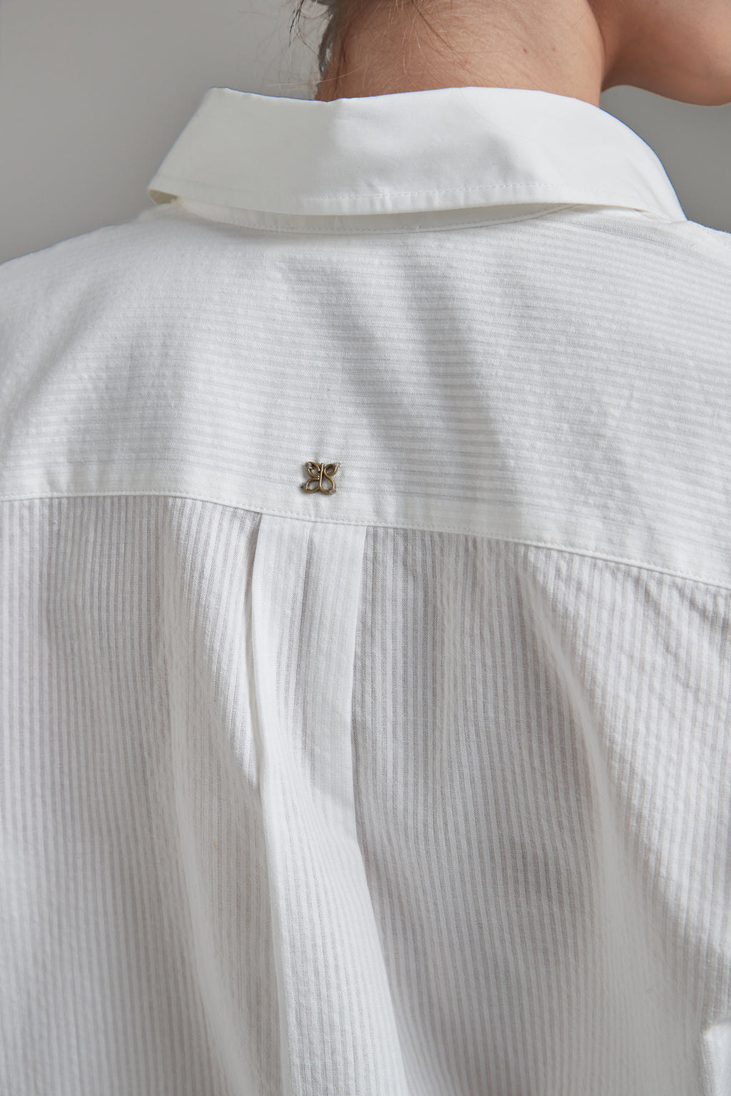 The Margot Shirt in Cloud White shown close-up from the back with tonal cotton shirting and logo hardware detail.