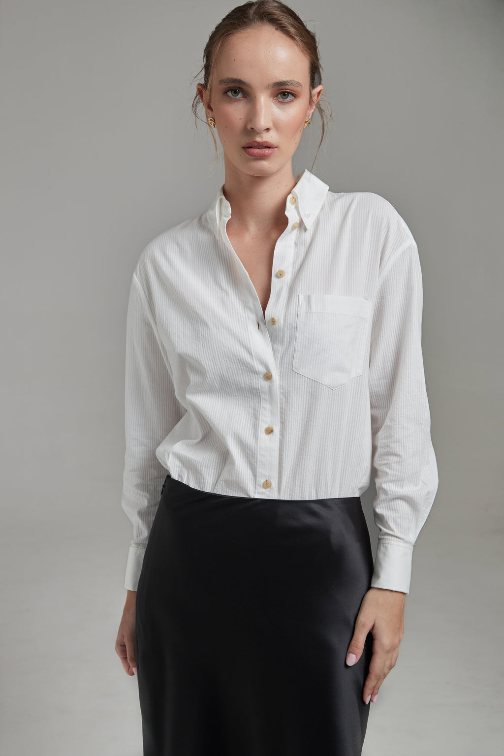 The Margot Shirt in Cloud White shown from the front with tonal cotton shirting, natural horn buttons and a relaxed silhouette.