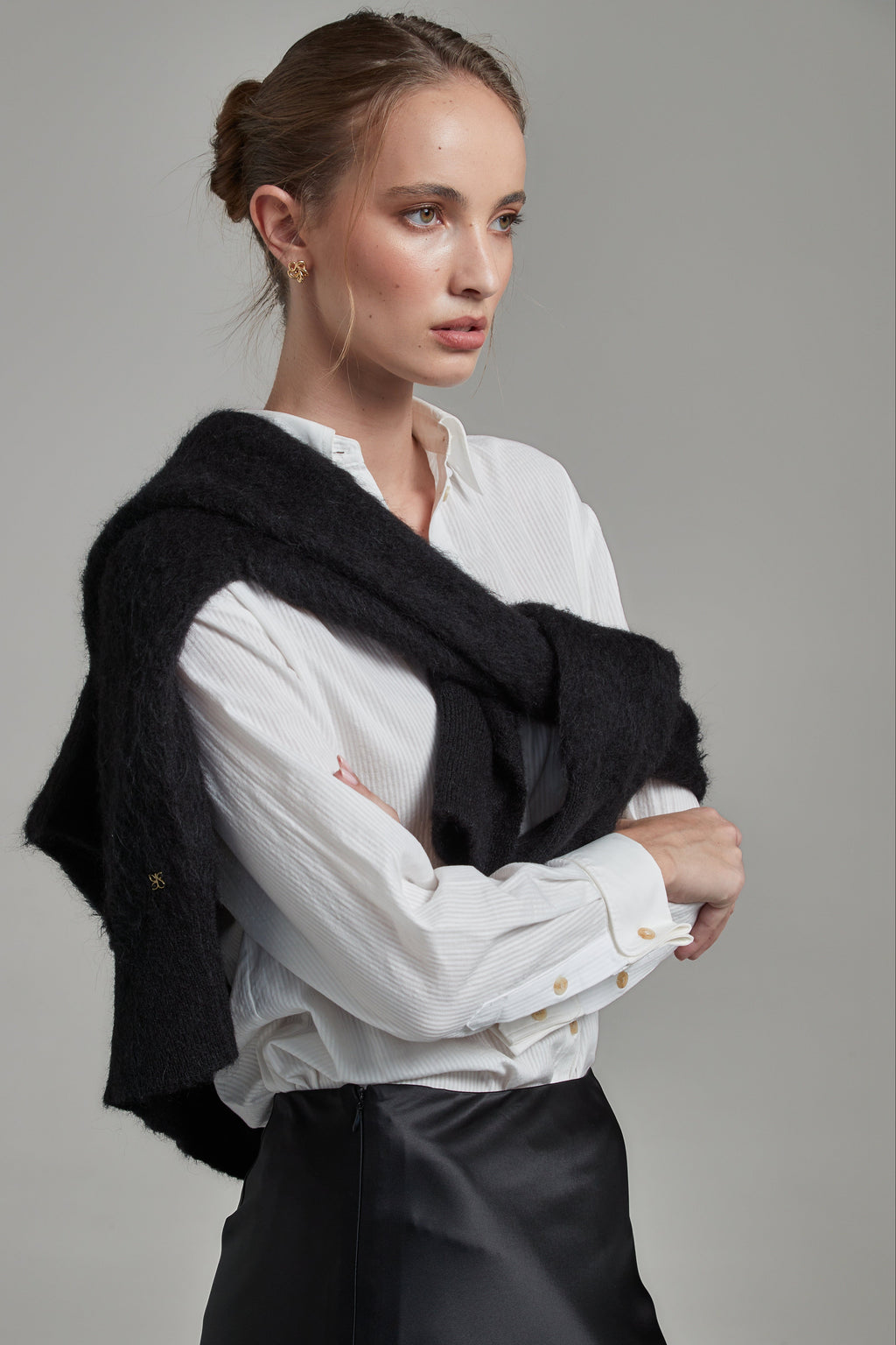 The Margot Shirt in Cloud White shown from the side layered with the Lauren Turtleneck in Midnight Black, featuring tonal cotton shirting and contrast knitwear.