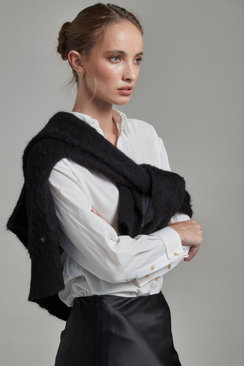 The Margot Shirt in Cloud White shown from the side layered with the Lauren Turtleneck in Midnight Black, featuring tonal cotton shirting and contrast knitwear.