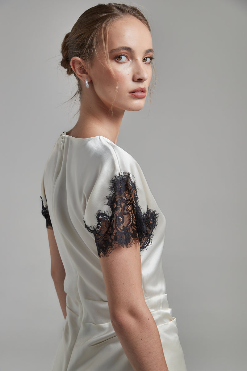 The Paloma Top in Feather White, a satin lace panel top shown from the side with black lace sleeve detailing and fitted silhouette.
