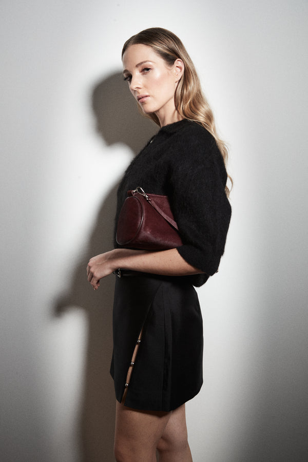 The Stella Polo Knit and Anya Mini Skirt in Midnight Black, an alpaca polo knit styled with a wool silk mini skirt.