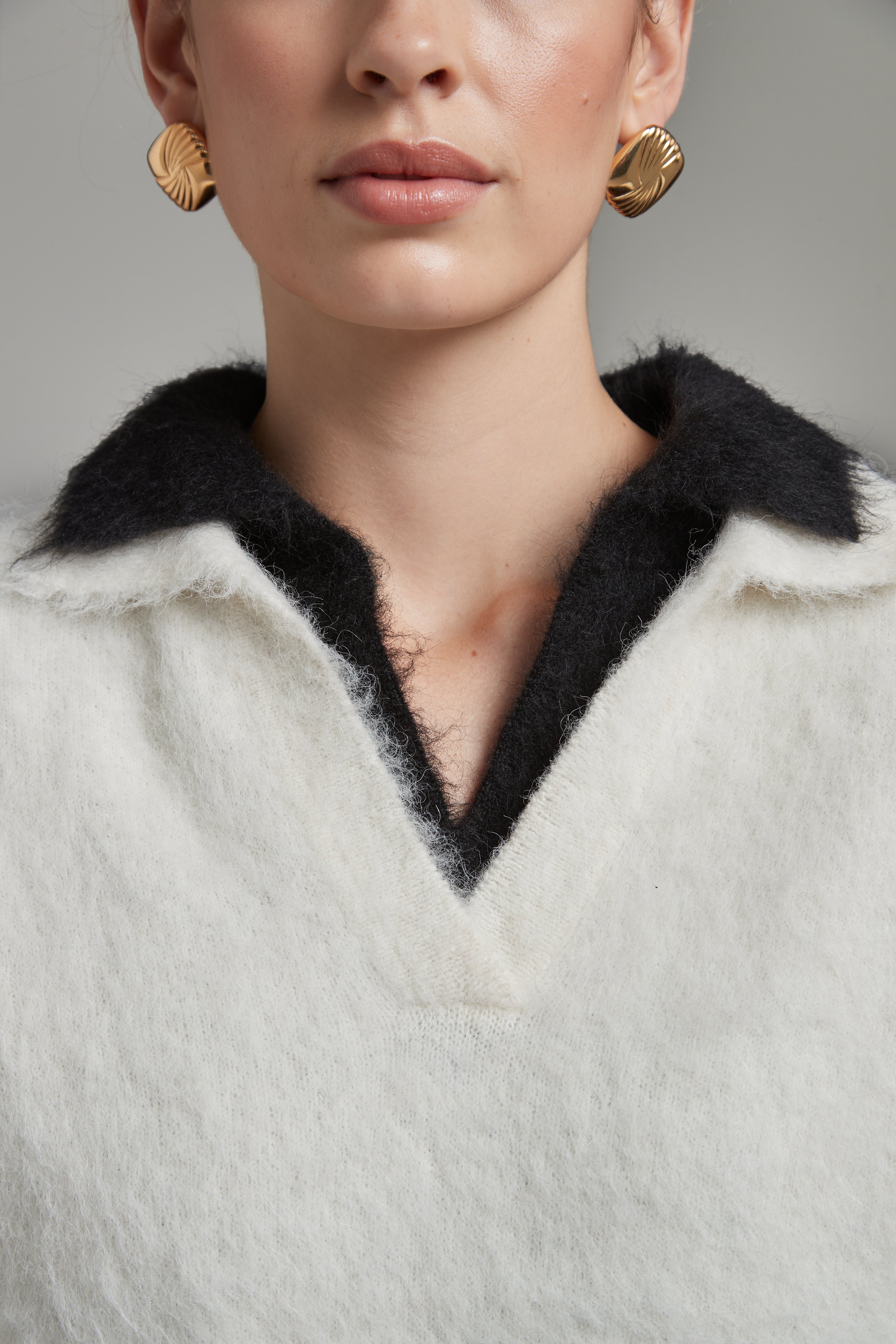 The Stella Polo Knit in Feather White and Midnight Black, an alpaca polo knit shown stacked to highlight both colourways and brushed texture.