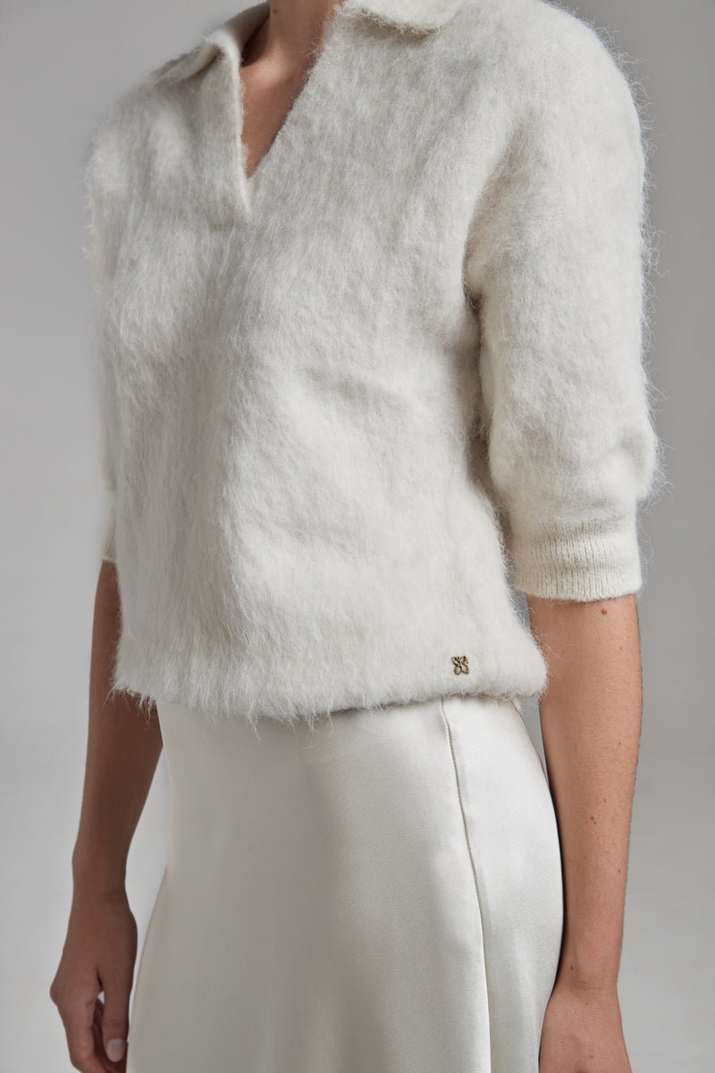 The Stella Polo Knit in Feather White shown from the side with short sleeves, a brushed alpaca-blend texture and soft stretch.