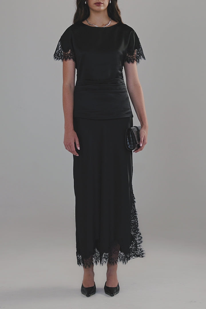 Video showing the Anouk Maxi Skirt in Midnight Black with close-up details of the satin finish, black lace trim and ankle-length silhouette.
