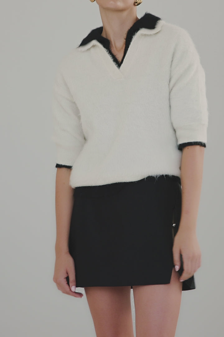Video showing the Stella Polo Knit in Feather White and Midnight Black, highlighting both colourways, brushed alpaca-blend texture and short-sleeve silhouette.