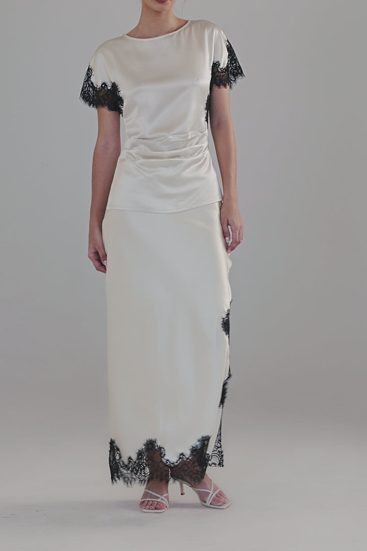 Video showing the Paloma Top in Feather White with close-up details of the satin finish, black lace panel detailing and fitted silhouette.